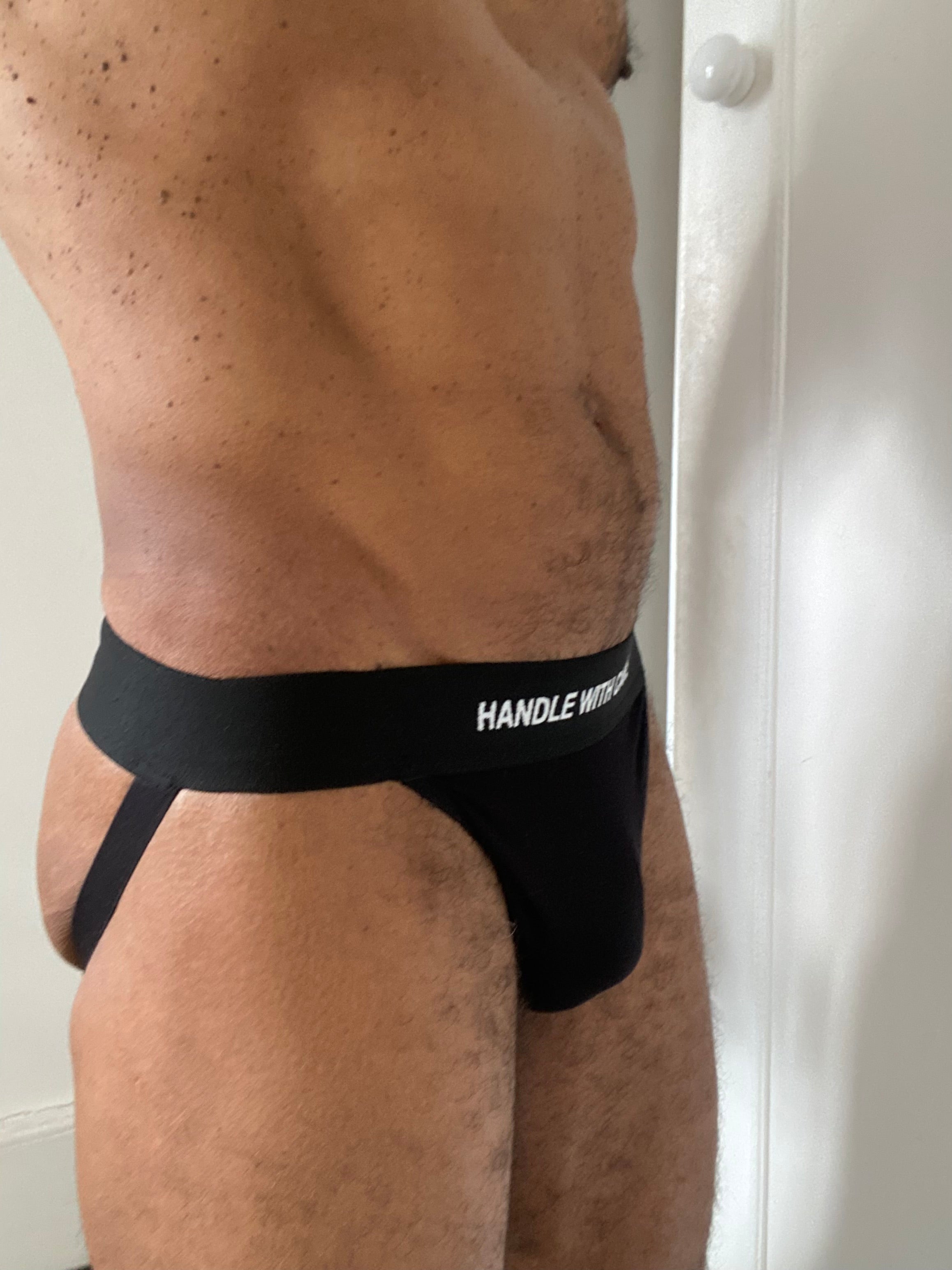 Black men's underwear with 'HANDLE WITH CARE' text on a plain background
