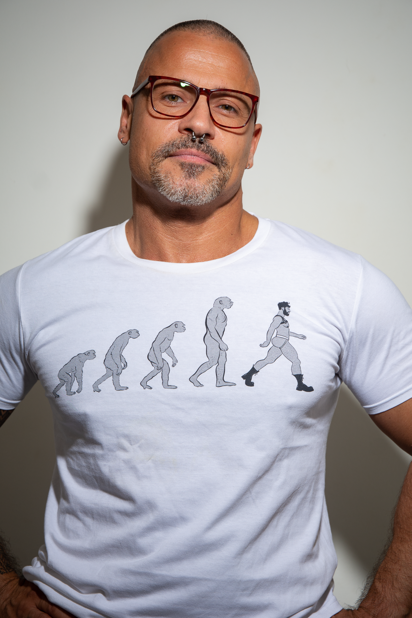 Handsome Middle aged man with glasses wearing a white Gayvolution T-shirt 