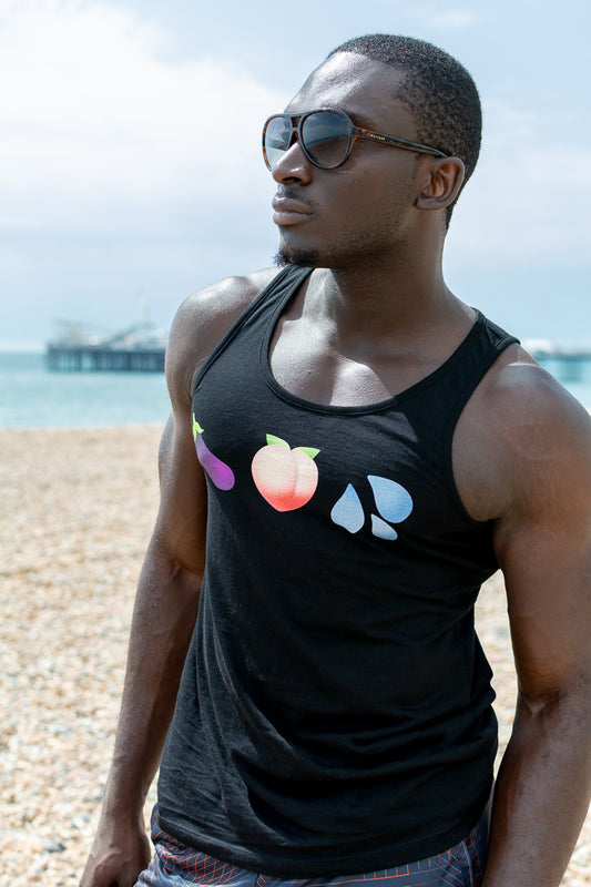 Man with sunglasses wearing Unapologaytic Healthy Diet tank top on Brighton beach
